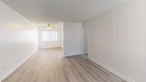 A room with a light brown floor and white walls.