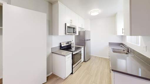 A kitchen with white cabinets and appliances.