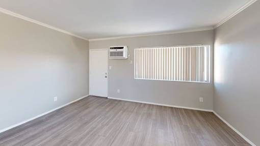 A room with a window and a wall-mounted air conditioner.
