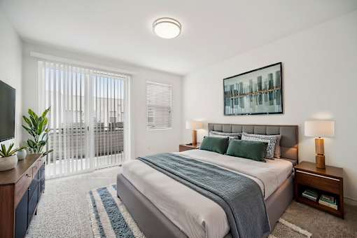 A bedroom with a large bed and a television on the side table.
