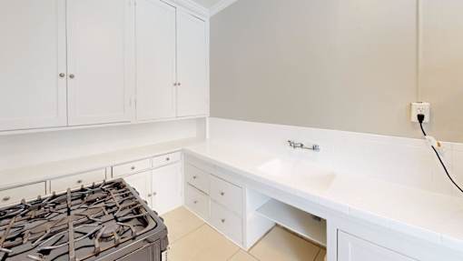 A white kitchen with a stove and cabinets.