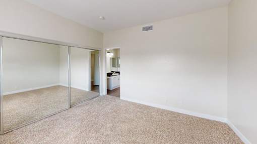 A room with a carpeted floor and a glass door.