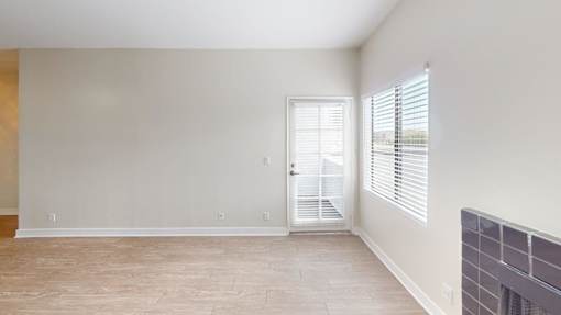 A room with a door and a window with blinds.