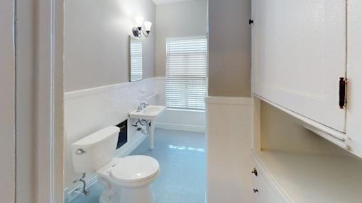 A white toilet sits next to a sink in a bathroom.