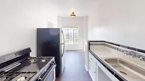 A kitchen with a black stove and a black fridge.