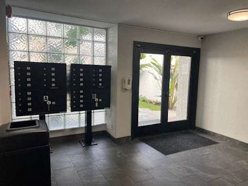 A room with a black door and a black mat on the floor.