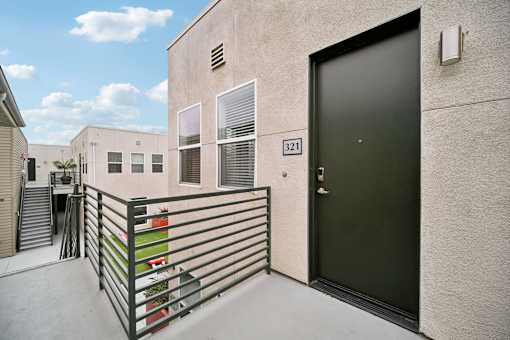 A black door is on the side of a building with a number 321 on it.