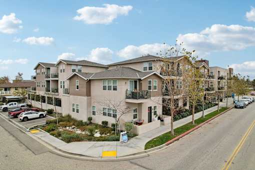 Apartment building with cars parked in front.
