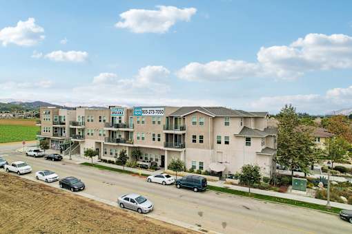 Apartment complex with cars parked in front.
