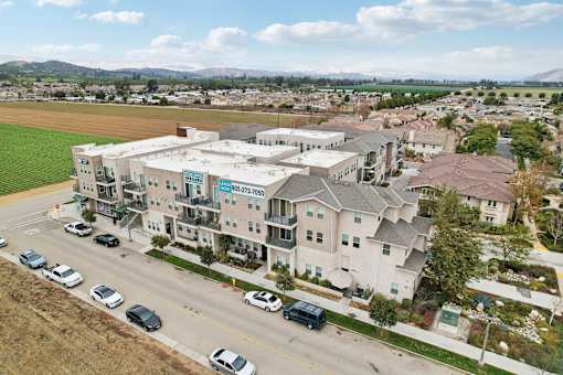 Apartment complex with cars parked in front.
