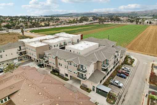 A large apartment complex with a parking lot in front.