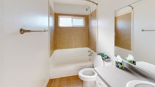 A white bathroom with a toilet, sink, and bathtub.