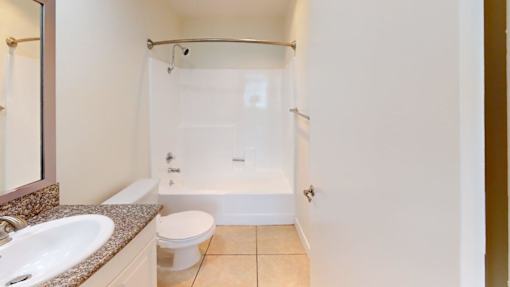 A white toilet sits next to a sink in a small bathroom.