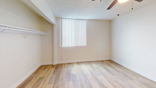 A room with a slanted ceiling and a window with blinds.
