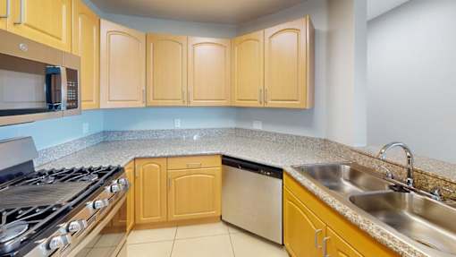 A kitchen with wooden cabinets and a stainless steel dishwasher.