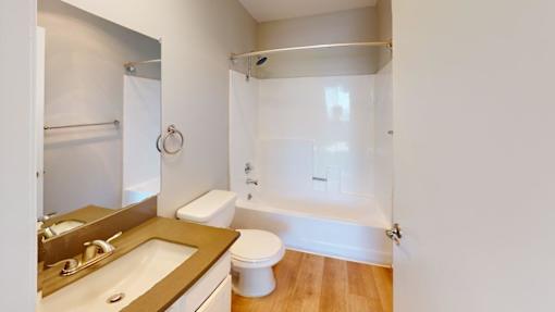 A white bathroom with a toilet, sink, and bathtub.