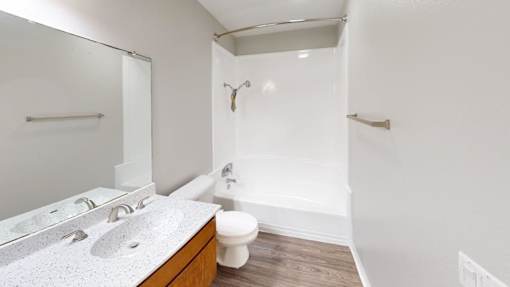 A white bathroom with a toilet, sink, and bathtub.