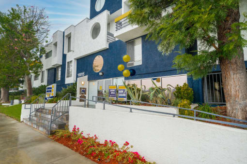 a blue and white building with a tree in front of it
