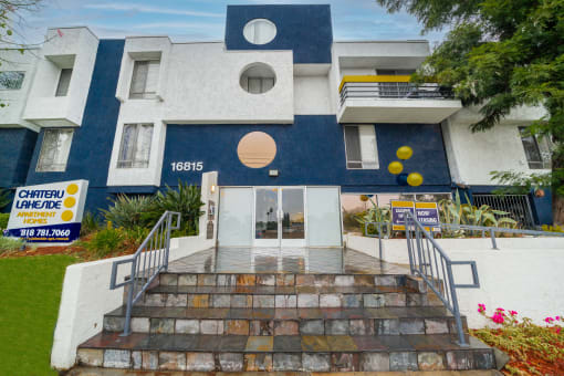 a blue and white building with yellow balloons in front of it