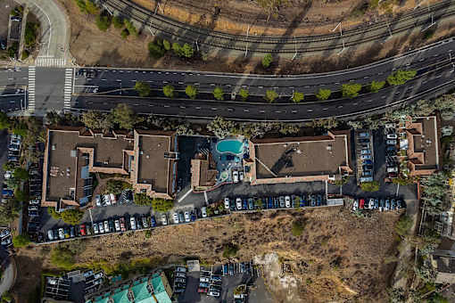 A bird's eye view of a residential area with houses and parked cars.