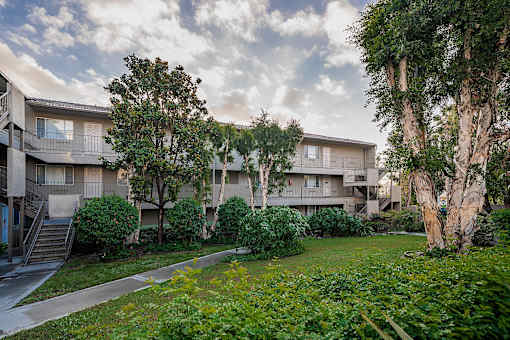 Apartment complex with greenery in front.
