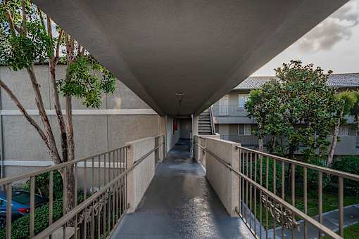 A long concrete walkway with a metal railing on both sides.