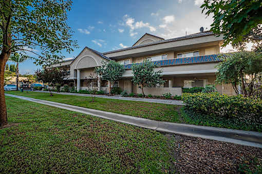 A building with a blue roof and a tree in front.
