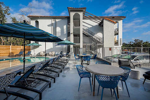 A patio with tables and chairs and a building in the background.