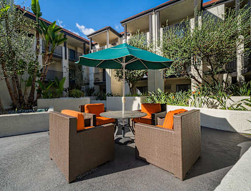 a patio with a table and chairs and an umbrella