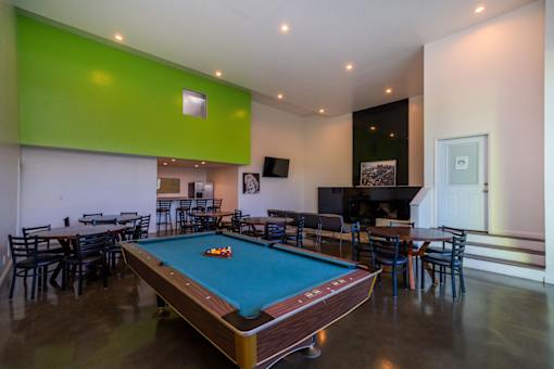 A pool table is in the middle of the room.