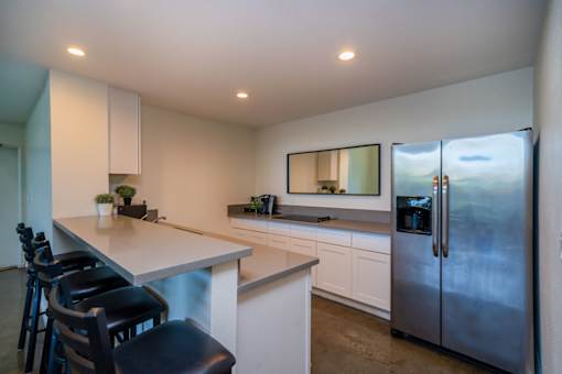 A modern kitchen with a large island and stainless steel appliances.