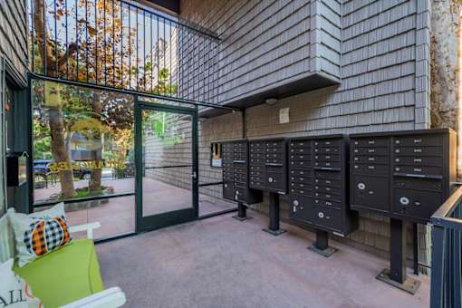 A row of mailboxes are lined up on a wall outside a building.