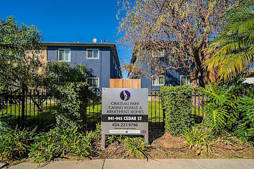 A sign for Chateau Park Casino Royale Apartments is in front of a building.