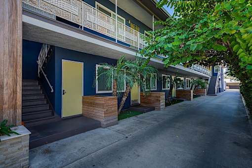 A long row of houses with blue walls and wooden steps leading to the front doors.