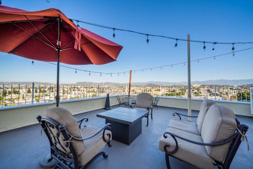 A patio with two chairs and a table with a view of the city.