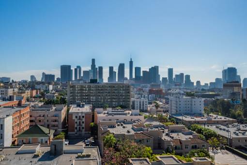 A cityscape with a mix of residential and commercial buildings under a clear sky.