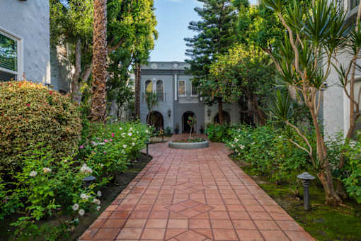 A garden pathway with a white house in the background.