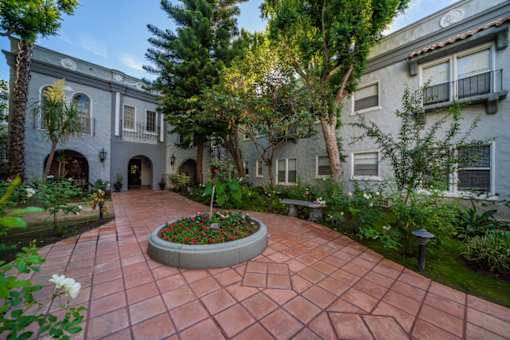 A courtyard with a circular flower bed in the middle.