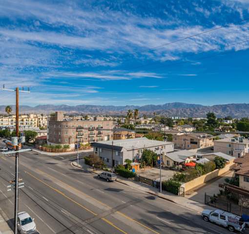 A street view of a residential area with cars parked on the side of the road.
