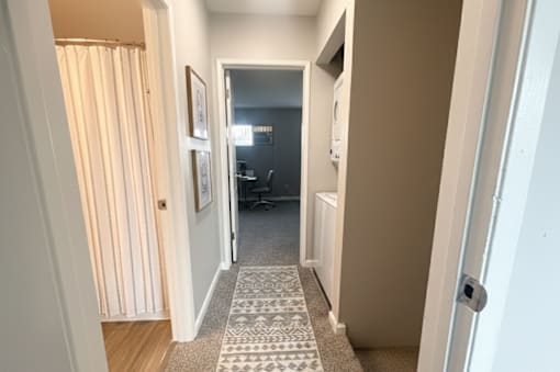 A hallway with a carpeted floor and a door on the right.