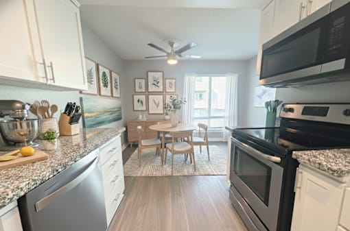 A kitchen with a dining table and chairs in the middle.