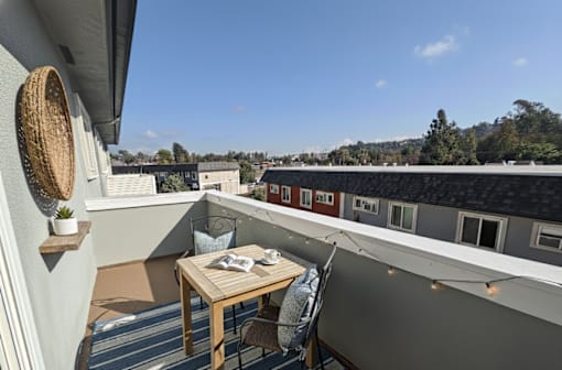 A balcony with a table and chairs overlooking a town.