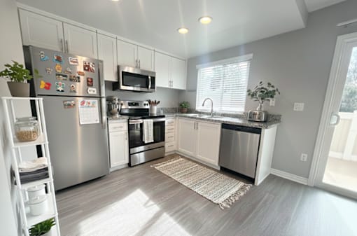 A modern kitchen with stainless steel appliances and white cabinets.