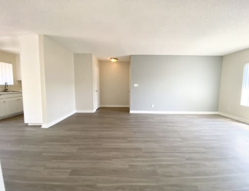 an empty living room with wood flooring and white walls