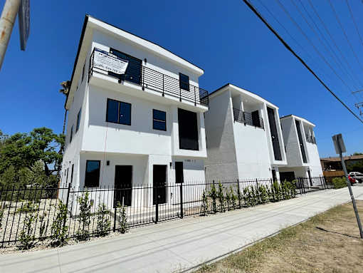 A white building with black railings and windows.