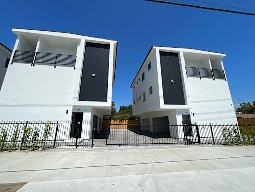 Two white houses with black doors and windows.