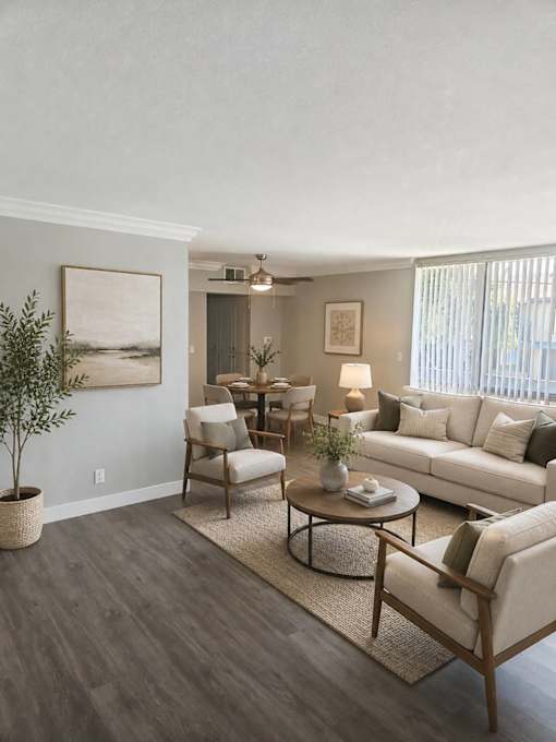 A living room with a white couch, a coffee table, and a potted plant.