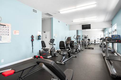 A gym with treadmills, exercise bikes, and other equipment.
