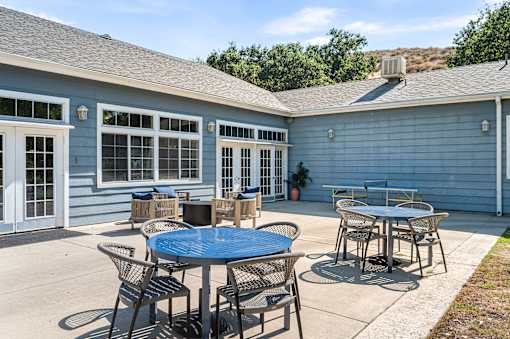 A blue house with a patio and a table.