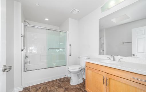 A bathroom with a toilet, sink, and walk-in shower.